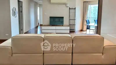 Spacious living room with modern decor and balcony view in a luxurious apartment.