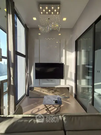 Luxurious modern living room with large TV and elegant chandelier