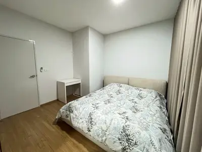 Cozy bedroom with modern decor and natural light, featuring a comfortable bed and minimalist design.