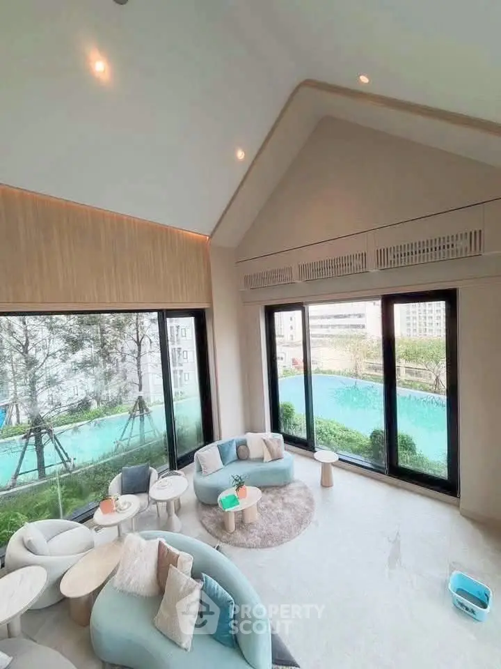 Luxurious living room with large windows offering stunning garden views, featuring modern furniture and elegant decor.