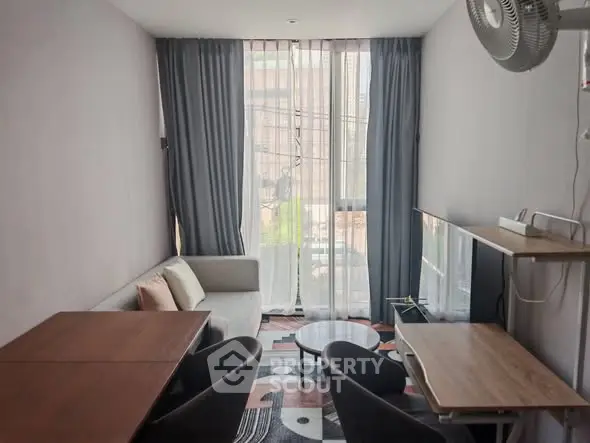Modern living room with stylish furniture and large window offering natural light.