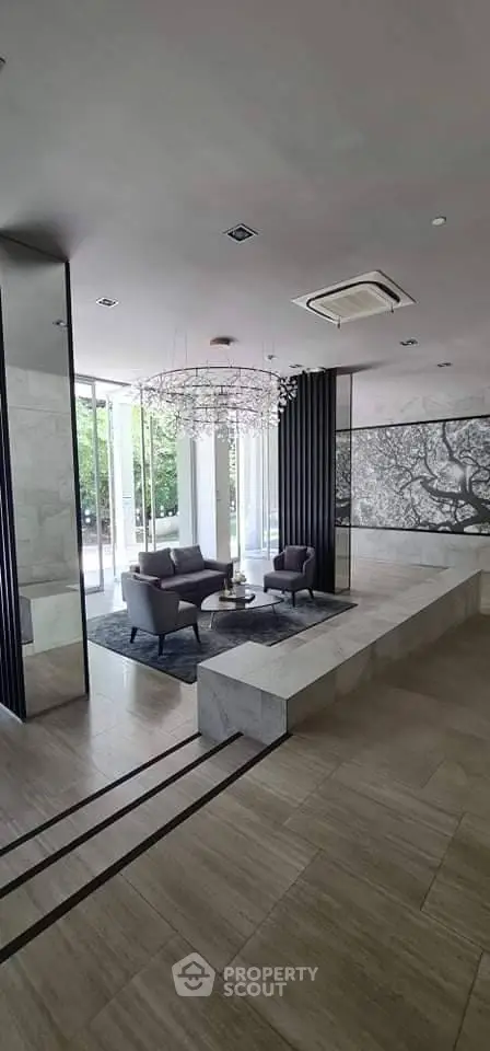 Luxurious modern lobby with elegant seating and artistic decor in a high-end building.