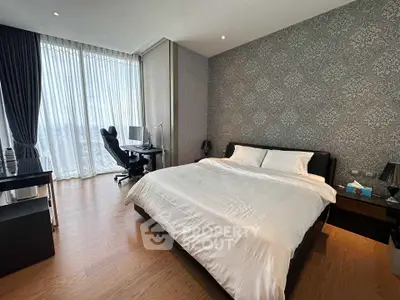 Luxurious bedroom with elegant decor and city view, featuring a comfortable bed and workspace.