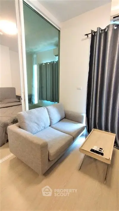 Cozy living room with modern sofa and sliding glass door leading to bedroom