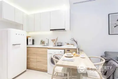 Modern compact kitchen with white appliances, sleek cabinetry, and a cozy dining area perfect for intimate meals and entertaining guests.