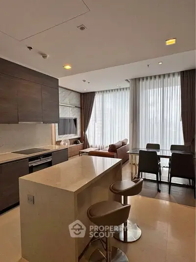 Modern open-layout kitchen and living area with sleek design and natural light.
