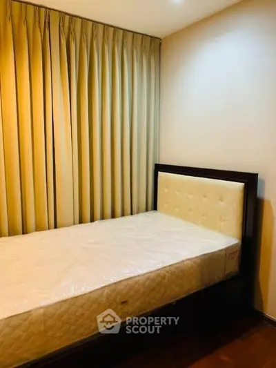 Cozy bedroom with elegant curtains and a comfortable single bed, perfect for restful nights.