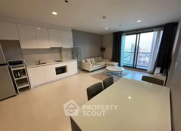 Modern open-plan living room and kitchen with city view balcony in luxury apartment.