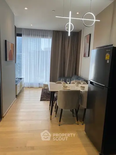 Modern open-layout kitchen and dining area with stylish lighting and large window view.