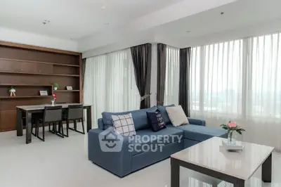 Spacious modern living room with large windows and elegant furnishings.