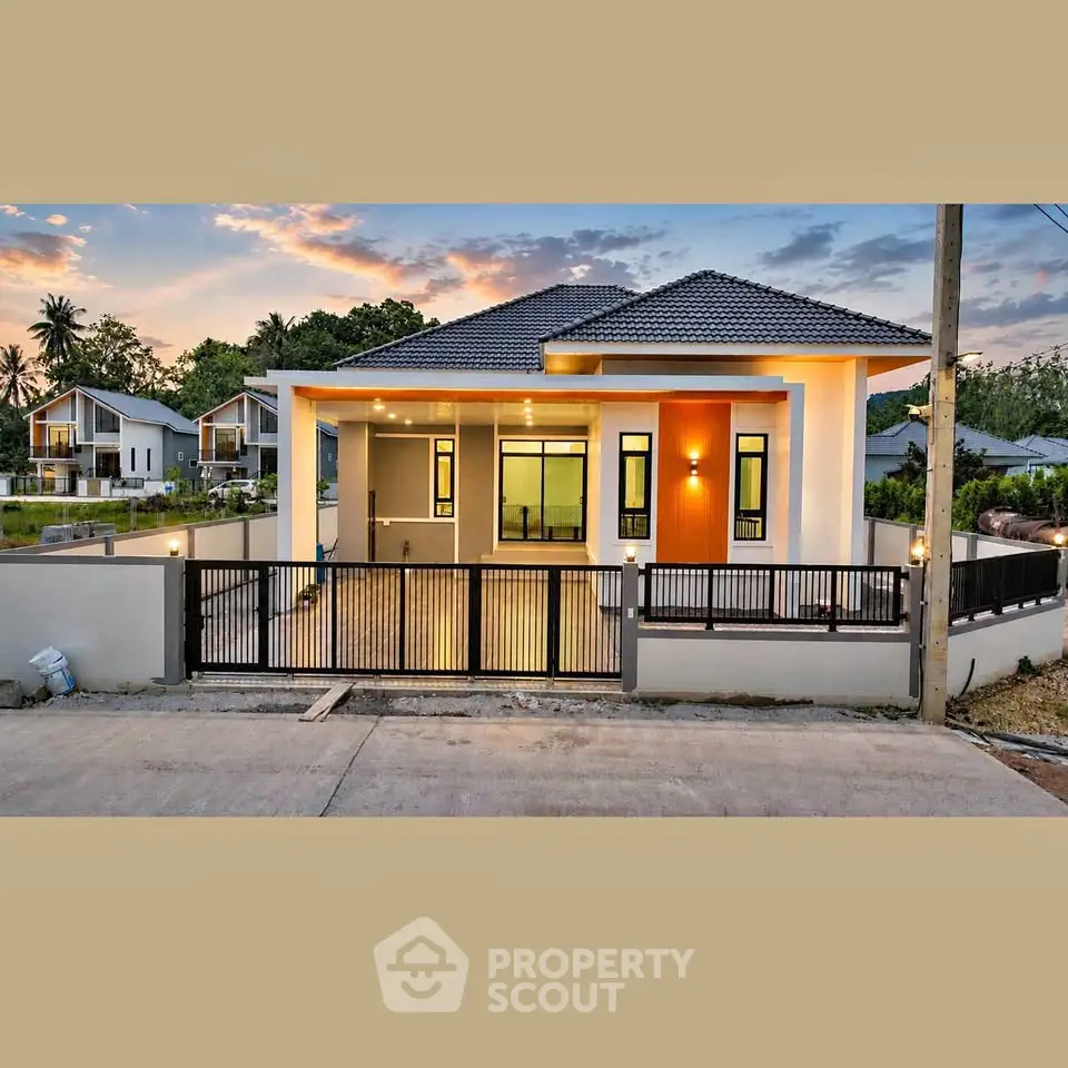 Modern single-story house with sleek design and spacious driveway at sunset.