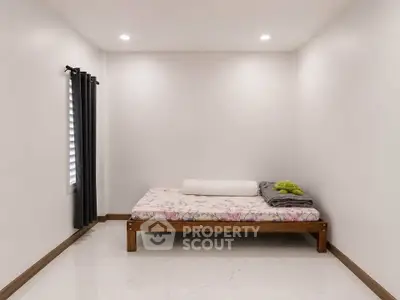 Minimalist bedroom with simple bed and elegant curtains in a cozy space.