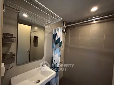 Modern bathroom with sleek sink and stylish shower curtain in contemporary design.