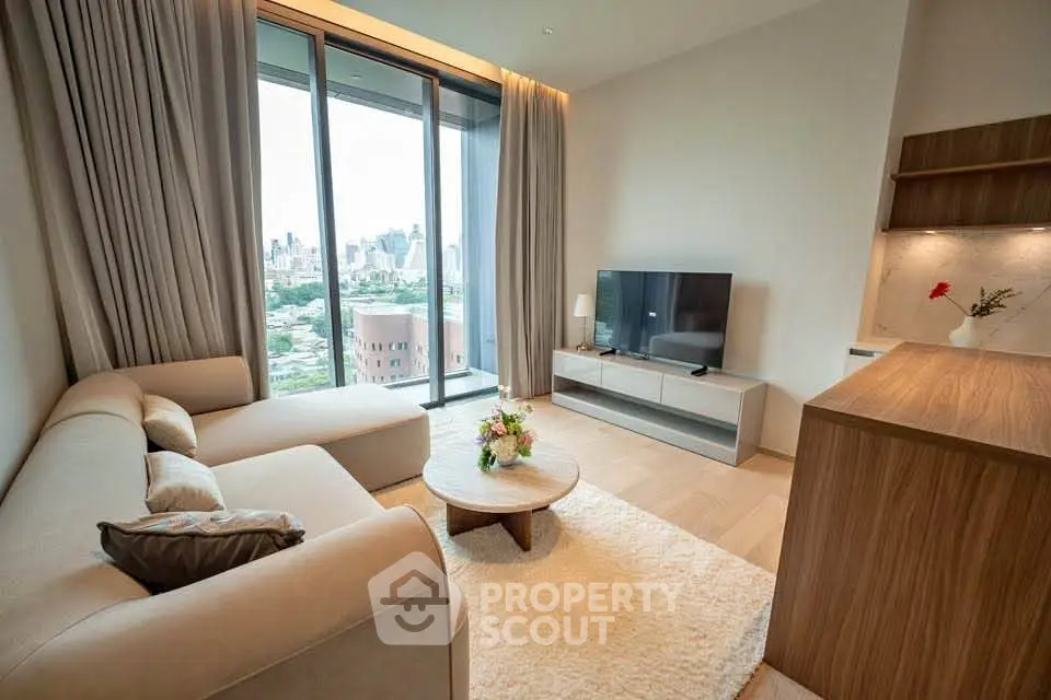 Modern living room with city view, featuring cozy sofa, TV, and elegant decor in a high-rise apartment.