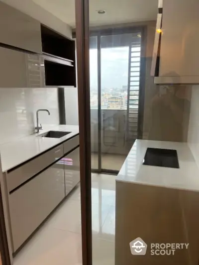 Modern kitchen with sleek cabinetry and city view from window