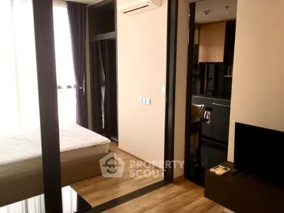 Modern apartment interior with bedroom and kitchen, featuring sleek design and natural light.