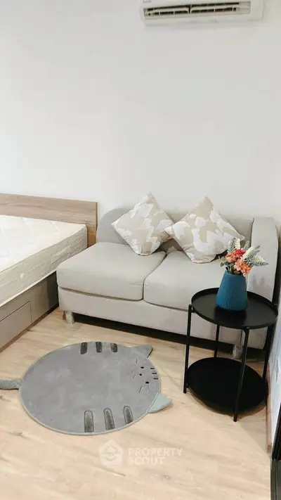 Cozy bedroom with stylish sofa and decorative accents in modern apartment.