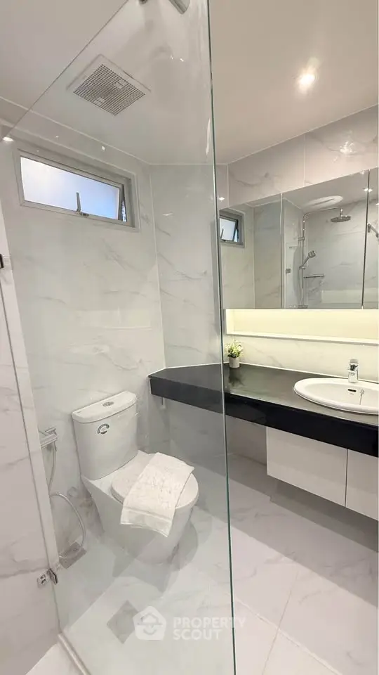 Modern bathroom with sleek design, glass shower, and elegant fixtures in a luxury apartment.