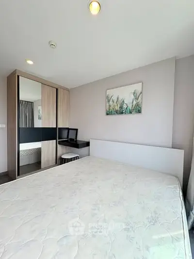 Modern bedroom with stylish decor and large mirrored wardrobe in a bright apartment.