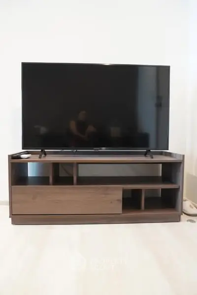 Modern living room with sleek TV stand and large flat-screen television.