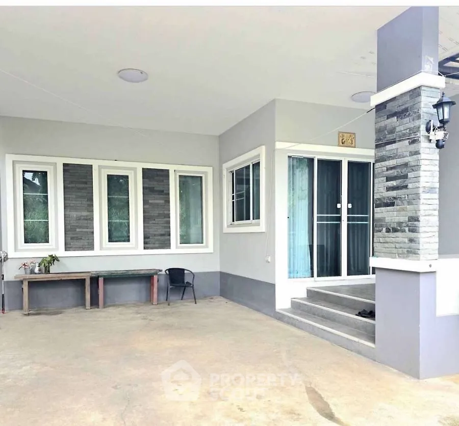Modern home entrance with stylish stone accents and spacious patio area.