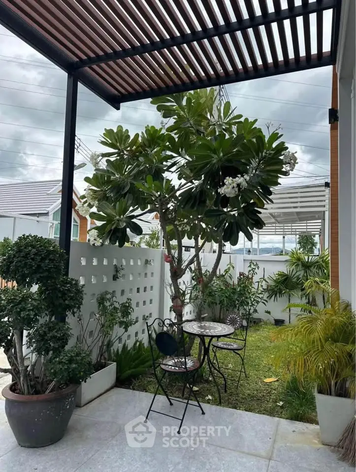 Charming garden patio with lush greenery and stylish outdoor seating, perfect for relaxation.