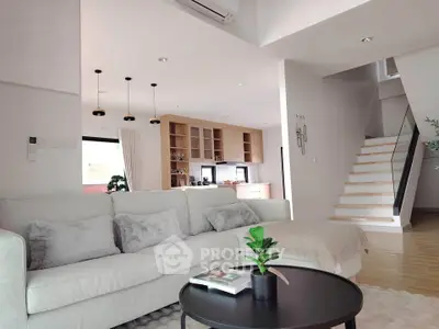 Modern living room with cozy sofa and stylish open kitchen