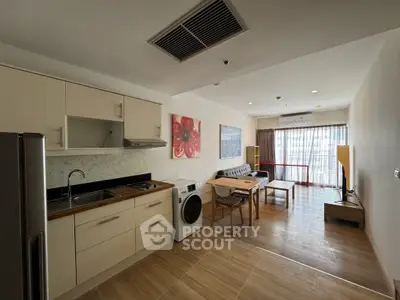 Modern open-plan living room and kitchen with natural light and stylish decor