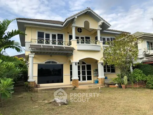 Charming two-story house with lush garden and elegant balcony in serene neighborhood.
