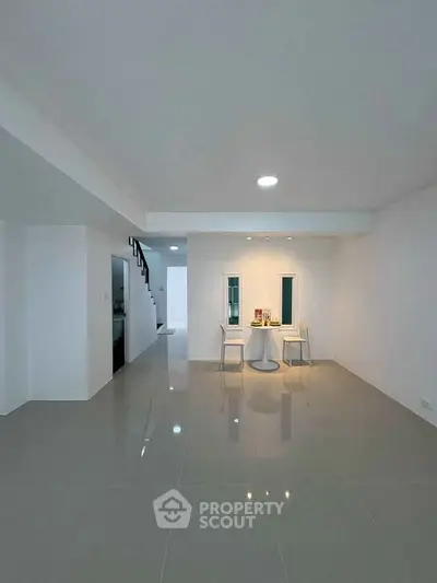 Spacious modern living area with sleek tile flooring and minimalist decor, perfect for contemporary living.