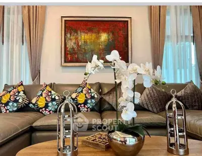 Elegant living room with stylish decor, featuring a plush sofa, vibrant cushions, and modern artwork.
