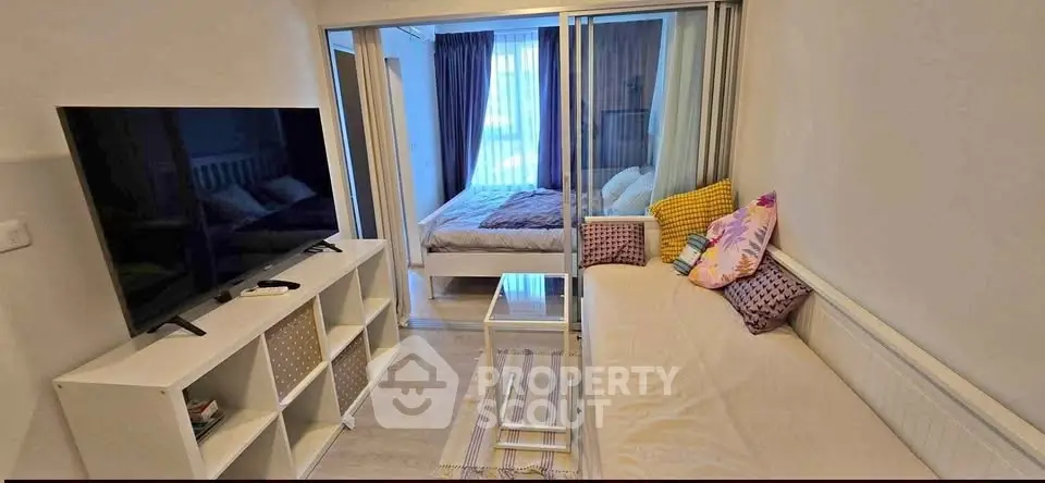 Modern living room with TV and cozy bedroom view in stylish apartment