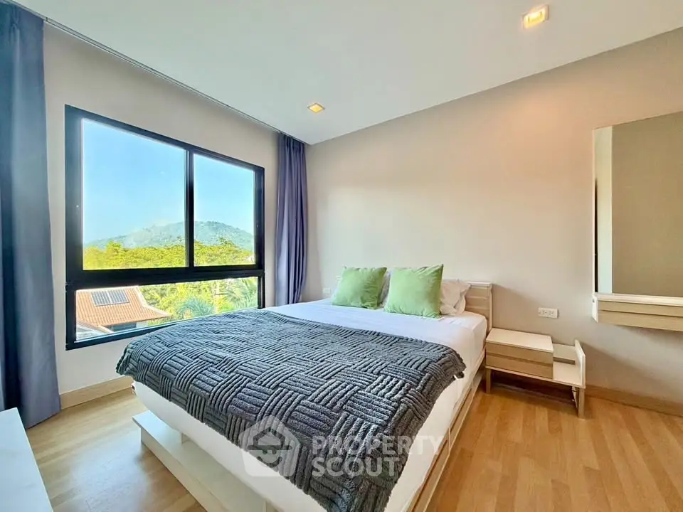 Bright bedroom with scenic window view and modern furnishings