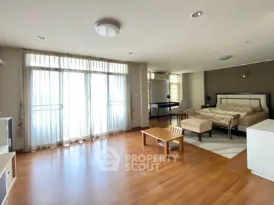 Spacious bedroom with elegant wooden flooring and natural light