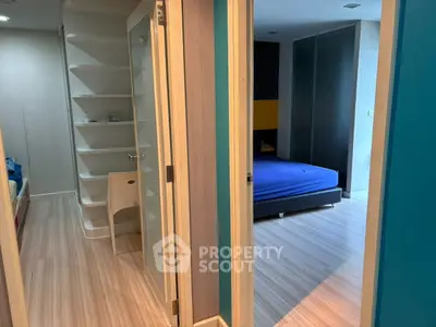Modern apartment interior with bedroom and study area, featuring sleek design and wooden flooring.