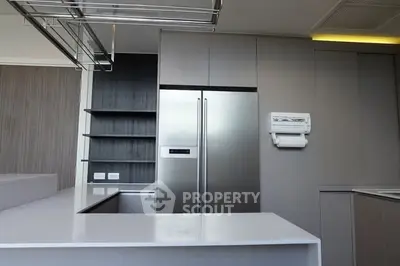 Modern kitchen with sleek cabinetry and stainless steel appliances in a contemporary apartment.