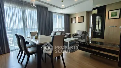 Spacious modern living room with elegant dining area and large windows offering natural light.