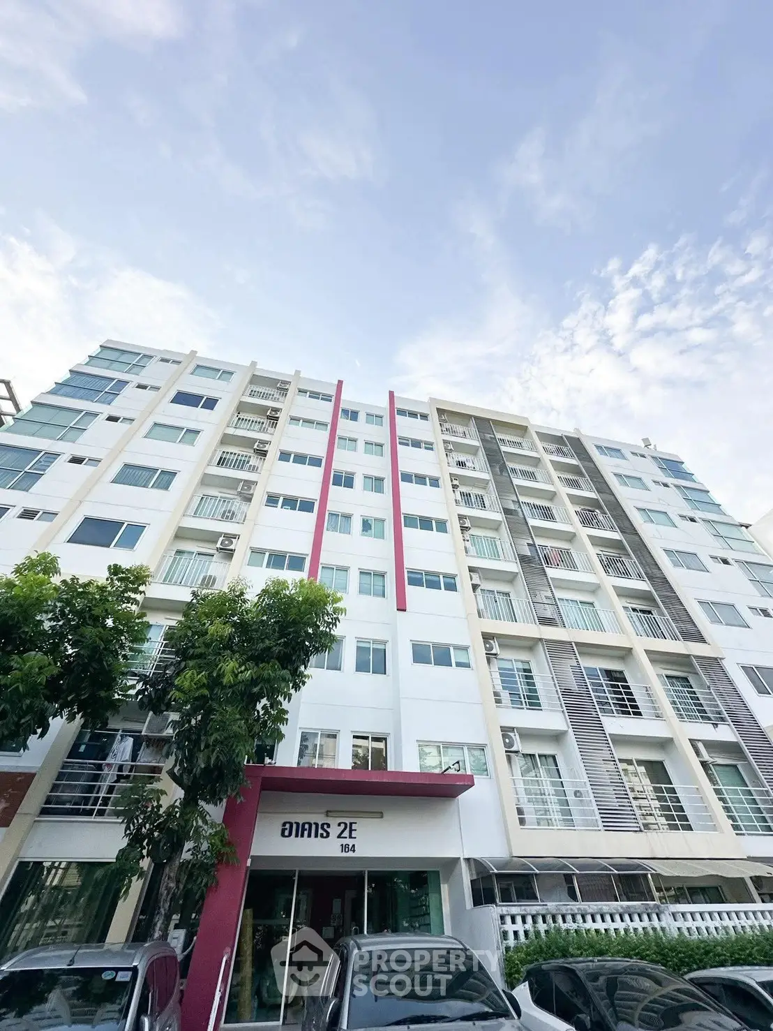 Modern multi-story residential building with contemporary design and large windows.