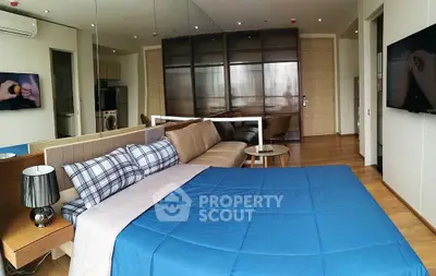 Modern bedroom with stylish decor and mirrored wardrobe in a cozy apartment.