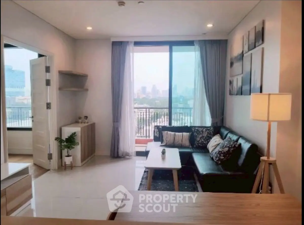 Modern living room with city view, stylish decor, and natural light.
