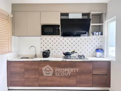 Modern kitchen with sleek cabinetry and gas stove, perfect for culinary enthusiasts.