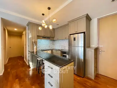 Modern kitchen with sleek cabinetry and stainless steel appliances in a stylish apartment.