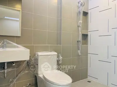 Modern bathroom with sleek tiles and new fixtures, showcasing a contemporary design.