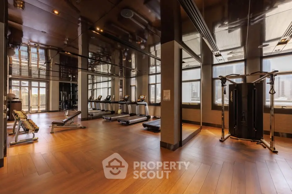 Luxurious gym with modern equipment and city view, perfect for fitness enthusiasts.