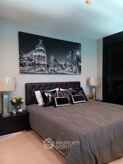 Luxurious bedroom with elegant decor and stylish artwork, featuring a plush bed and chic lighting.