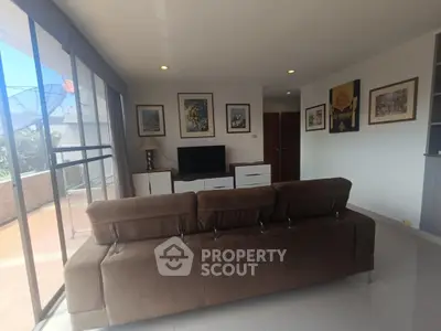 Spacious living room with modern decor and large windows offering natural light.