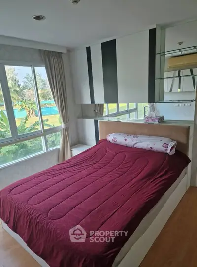 Cozy bedroom with large window offering scenic views and modern decor, perfect for relaxation.