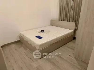Modern minimalist bedroom with wooden flooring and neutral tones.