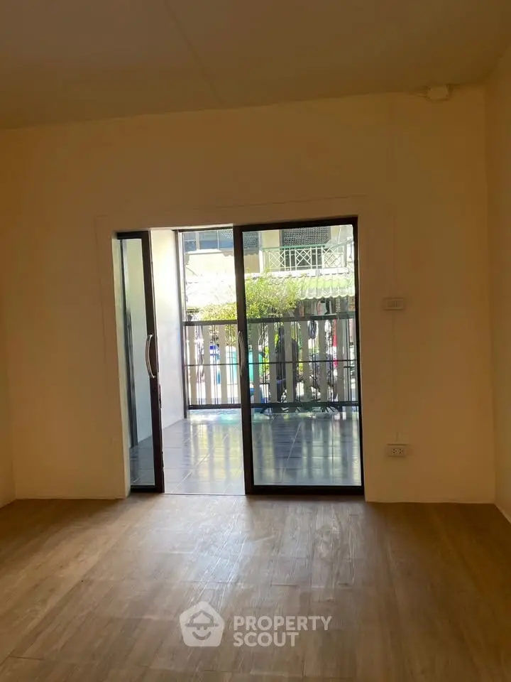 Spacious room with sliding glass doors leading to a balcony, offering natural light and outdoor access.