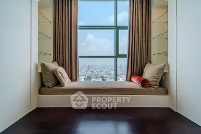 Luxurious window seat with panoramic city view in modern high-rise apartment.